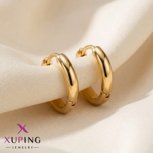یک جفت گوشواره حلقه‌ای بزرگ، ساده و کلاسیک طلایی رنگ برند ژوپینگ قرار گرفته روی پارچه حریر روشن