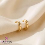 یک جفت گوشواره حلقه‌ای متوسط، ساده و کلاسیک طلایی رنگ برند ژوپینگ قرار گرفته روی پارچه حریر روشن