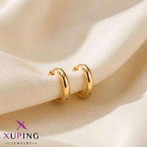 یک جفت گوشواره حلقه‌ای متوسط، ساده و کلاسیک طلایی رنگ برند ژوپینگ قرار گرفته روی پارچه حریر روشن