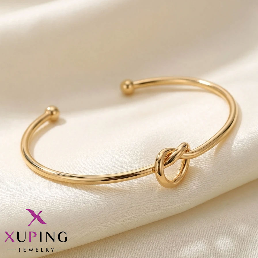 Golden-knot-bangle دستبند النگویی (بنگل) زنانه رنگ طلایی با طراحی باز و طرح گره مینیمال در مرکز آن