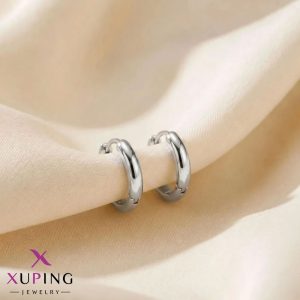 یک جفت گوشواره حلقه‌ای متوسط ۱.۳ سانتی‌متری، ساده و کلاسیک نقره‌ای رنگ برند ژوپینگ قرار گرفته روی پارچه حریر روشن